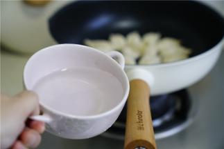然后再加入少许的玉米油，煎至饺子底面微焦脆，再加入适量的清水。