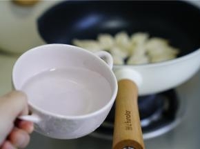 然后再加入少许的玉米油，煎至饺子底面微焦脆，再加入适量的清水。