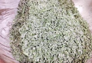 分三次，每次放入一把面粉，把它们和匀，和好后每粒韭菜都沾上了一层薄薄的面粉。