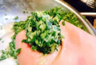 用手抓住一团韭菜糊，从虎口挤出直径约4～5厘米左右的小圆子，放入油锅中。