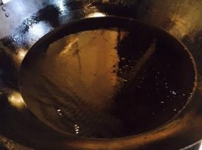 开大火置锅，锅热后放入大量的油，当油的表面有波纹动时，改中小火，准备炸小丸子。