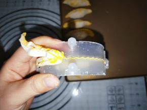 对折压紧，把多余的面皮撕掉