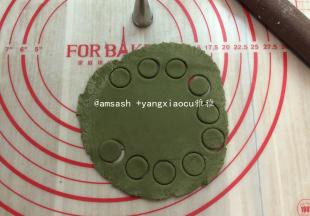 取出抹茶味面团，擀开用裱花嘴压出做南瓜蒂，然后再取一小块搓成橄榄形状，然后对半切开