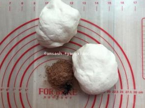 将揉好的面团平均分割成两份，剩下的一半放回面包机桶内，防止面团表面变干,取一份加入可可粉，揉至可可粉和面团完全混合均匀