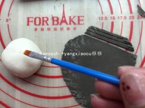 然后把大的面团分成5等份，用保鲜膜盖，以防面皮干燥，取出黑色面团擀成薄片，用刮板切成细丝条状，取出一个白面团，表面刷上水或牛奶，然后把细丝贴上做成一个网状，然后再用手指轻轻按压一下