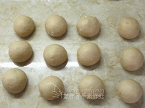 面团挤压排气后，均分成12个小面团，滚圆松弛15分钟。