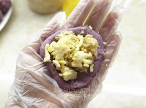 面团松弛期间我们来做內馅。紫薯芋泥搓圆之后压扁，中间放上马苏里拉芝士和肉松。