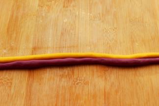 分别把两块面团用手搓成细长条，如图：