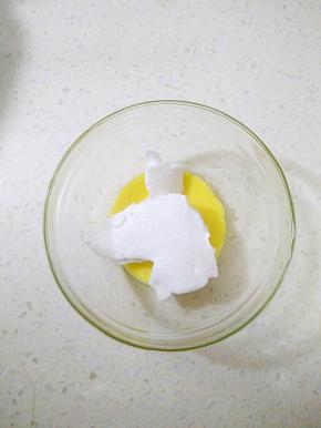 取出25克蛋黄倒入干净的容器，分两次加入35克蛋白霜翻拌均匀。