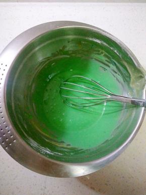 打蛋盆里的蛋黄糊加入蓝色素搅拌均匀，取三分之一蛋白霜与蛋黄糊混合均匀，再倒回剩余的蛋白霜内，搅拌均匀。
