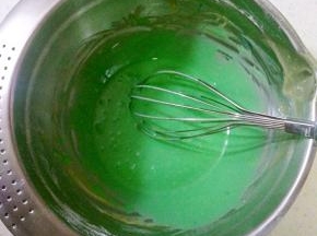 打蛋盆里的蛋黄糊加入蓝色素搅拌均匀，取三分之一蛋白霜与蛋黄糊混合均匀，再倒回剩余的蛋白霜内，搅拌均匀。
