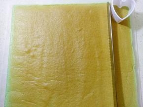 把两段边斜角切掉，用锯齿刀切出心形模具宽度的一条蛋糕卷备用（做小象耳朵）。