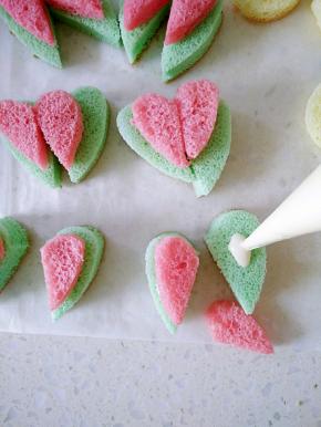 把心形蛋糕从中间切开，低入融化的巧克力再放上粉色的半块耳朵。