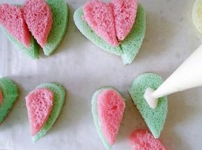 把心形蛋糕从中间切开，低入融化的巧克力再放上粉色的半块耳朵。