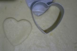 冷藏好的面团在油纸内擀成厚度为2mm左右的面饼，用心形模具压出形状