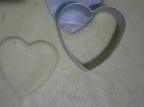 冷藏好的面团在油纸内擀成厚度为2mm左右的面饼，用心形模具压出形状