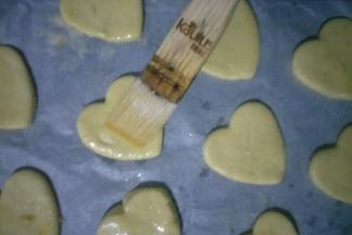 烤盘铺油纸，将饼干依次做好摆在烤盘中，中间留出一定的距离。在饼干表面刷一层鸡蛋液