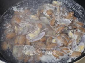 九阳轻奢派炒锅倒入适量水，煮开之后加入花蛤，煮到花蛤开始开口立即关火，将花蛤捞出来。