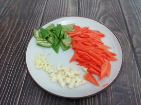 胡萝卜洗干净去皮切成片，青椒去籽切成块，蒜和姜切成粒