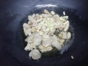 再放入姜、蒜粒，炒出蒜香味，再倒入少许的酱油翻炒均匀