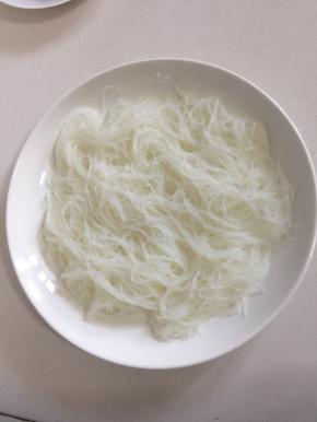 把泡软的粉丝铺在盘底。