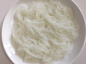 把泡软的粉丝铺在盘底。