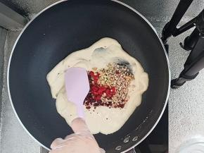 然后倒入果干碎和坚果碎翻炒均匀。