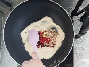 然后倒入果干碎和坚果碎翻炒均匀。
