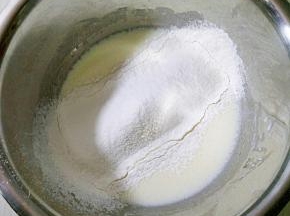 玉米油加入牛奶搅打均匀，充分乳化，打到颜色发白，筛入低筋面粉。