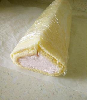 用双手从中间对齐蛋糕卷，成三角形状，用保鲜膜包紧，放冰箱冷藏定型。