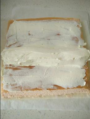 淡奶油加糖打发抹在蛋糕正面薄薄一层，香蕉去皮切掉两端，放在蛋糕中心位置，把剩下的奶油全涂在香蕉周围，借助擀面杖卷起底部油纸一端往上折压往前推，蛋糕卷成O型，用油纸包起来放冰箱冷藏定型。