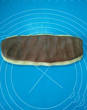 用手按压，白色面团放底下，上面放可可面团。