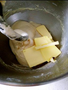 将面团材料除黄油外放进厨师机，和面10分钟，揉至扩展阶段，加入黄油。