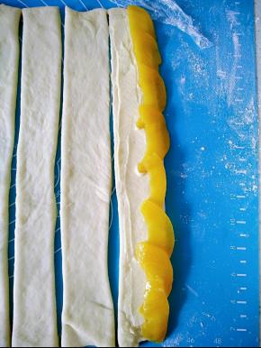 在面团上铺上一层黄桃片。