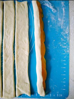 将面团对折，自上而下卷起，摆放在模具中。