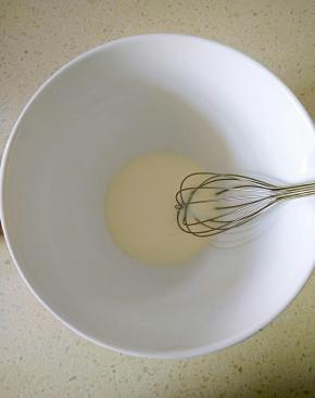 牛奶和玉米油倒入打蛋盆，用手动打蛋器搅打均匀。