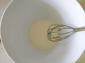 牛奶和玉米油倒入打蛋盆，用手动打蛋器搅打均匀。