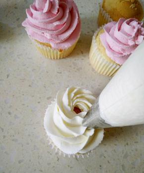 白色奶油裱花袋垂直转圈挤在蛋糕上。