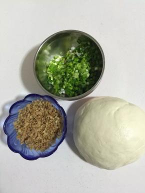 面粉加适量的温水，少许的盐，揉成光滑的面团。盖上保鲜膜醒面15分钟！葱洗净切成葱花，剁好的猪油渣装在碗里备用。