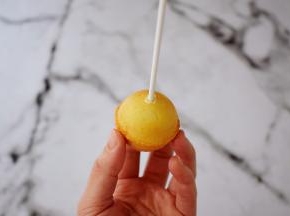 然后将巧克力隔水融化，用棒棒醮上少许巧克力插入蛋糕内，再裹上巧克力，撒上彩色糖珠和彩色糖针装饰即可