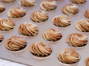 垂直拿好裱花袋，轻轻往上提，旋转一圈，稍用力挤出面糊