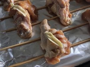 烤箱预热190度5分钟，鸡翅根放入烤盘，表面涂上黄油