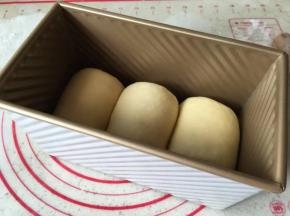 将面团平均分成6份  滚圆  盖保鲜膜 松弛20分钟   松弛好的面团擀成牛舌状 卷起来  反复两次  卷好后放入吐司盒2发  