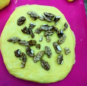 轻轻擀开，放入经过烘烤的核桃，如果喜欢葡萄干，也可用朗姆酒浸泡后加入。