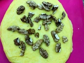 轻轻擀开，放入经过烘烤的核桃，如果喜欢葡萄干，也可用朗姆酒浸泡后加入。
