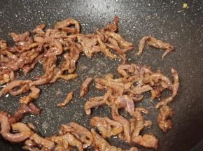 热锅热油下牛肉丝爆炒变色。