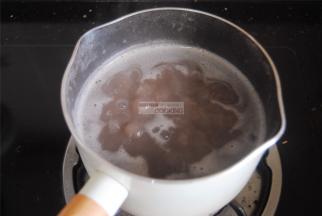 取打好的红豆沙3大勺放入奶锅内，加入适量的清水和桂圆肉，煮沸焖8分钟。