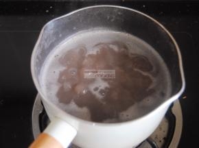 取打好的红豆沙3大勺放入奶锅内，加入适量的清水和桂圆肉，煮沸焖8分钟。