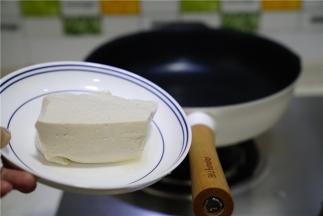 轻奢派不粘锅里加少许油，将豆腐改刀下锅煎出味。