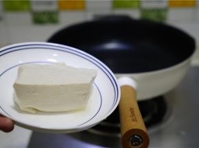 轻奢派不粘锅里加少许油，将豆腐改刀下锅煎出味。